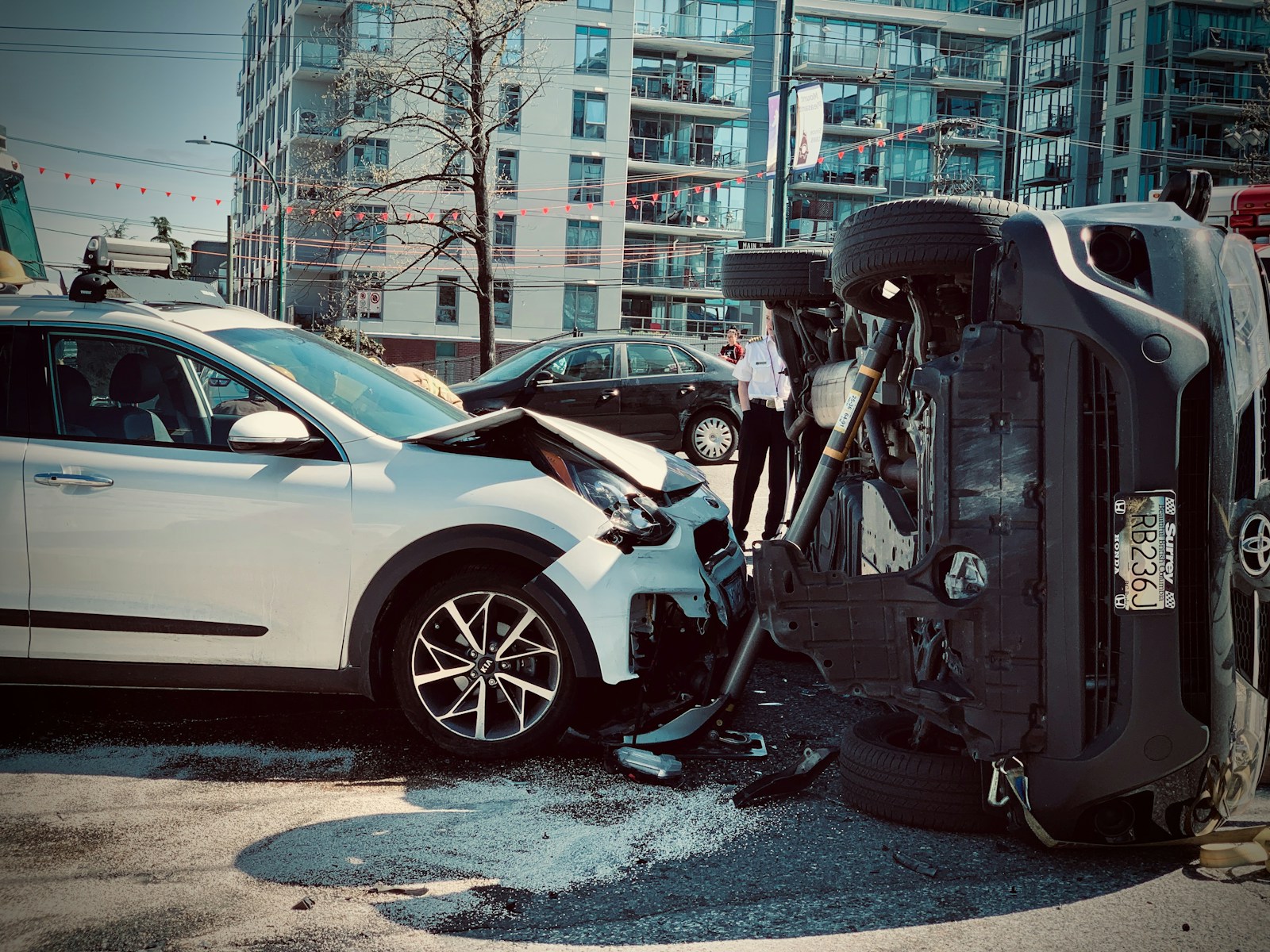 Rollover car crash automobile traffic accident broadside collision causing rollover with first responder firemen stabilization brace deployed.